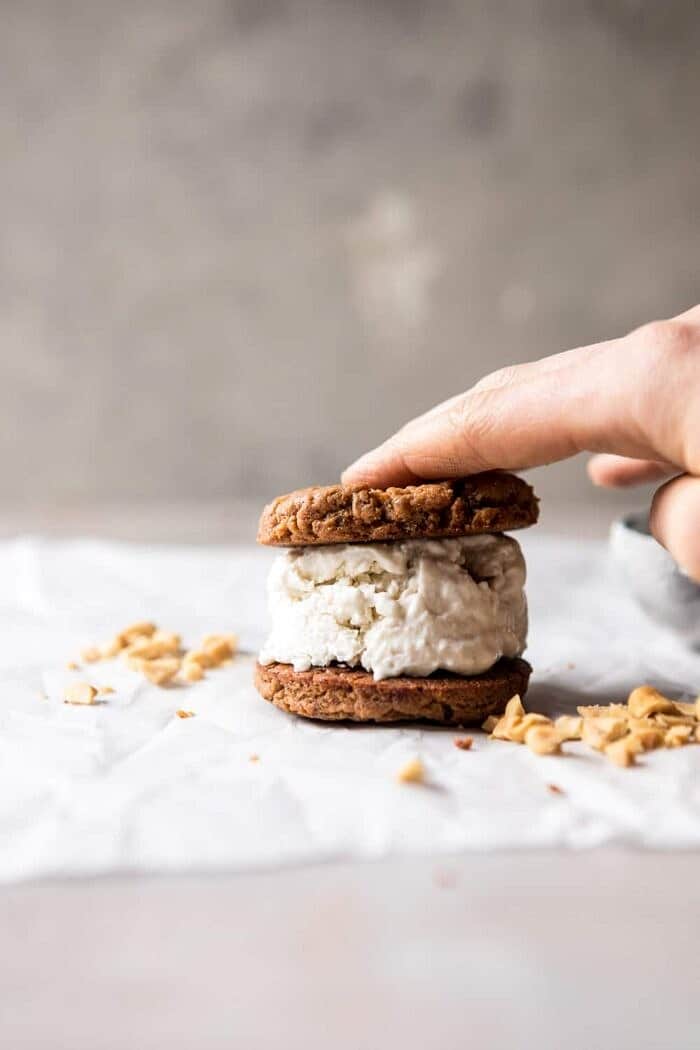 Chocolate Dipped Peanut Cookie Ice Cream Sandwiches | halfbakedharvest.com #icecream #chocolate #peanutbutter #summer sandwiching the cookies and ice cream together for Chocolate Dipped Peanut Cookie Ice Cream Sandwiches