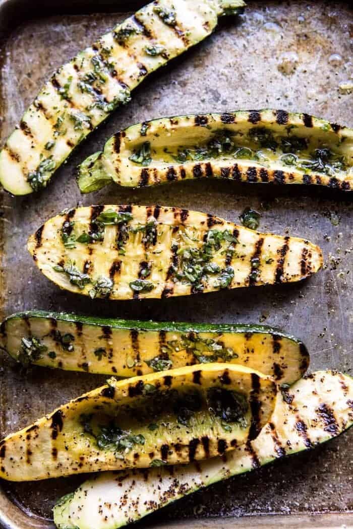 Grilled Pesto Zucchini Stuffed with Tomatoes and Orzo | halfbakedharvest.com #grilling #summer #easyrecipes overhead photo of grilled zucchini