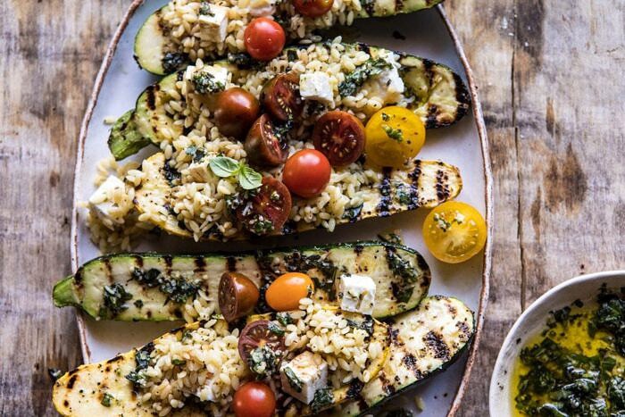 Grilled Pesto Zucchini Stuffed with Tomatoes and Orzo | halfbakedharvest.com #grilling #summer #easyrecipes overhead horizontal photo Grilled Pesto Zucchini Stuffed with Tomatoes and Orzo