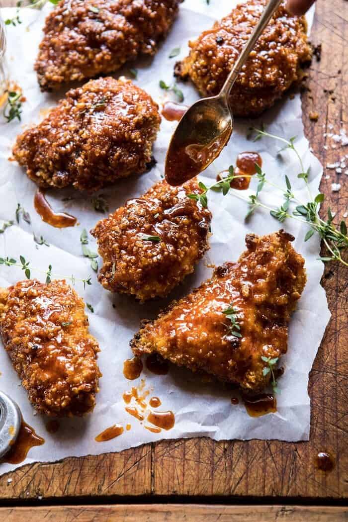 Oven Fried Southern Hot Honey Chicken | halfbakedharvest.com #chicken #healthy #recipes #easy adding sauce to Oven Fried Southern Hot Honey Chicken
