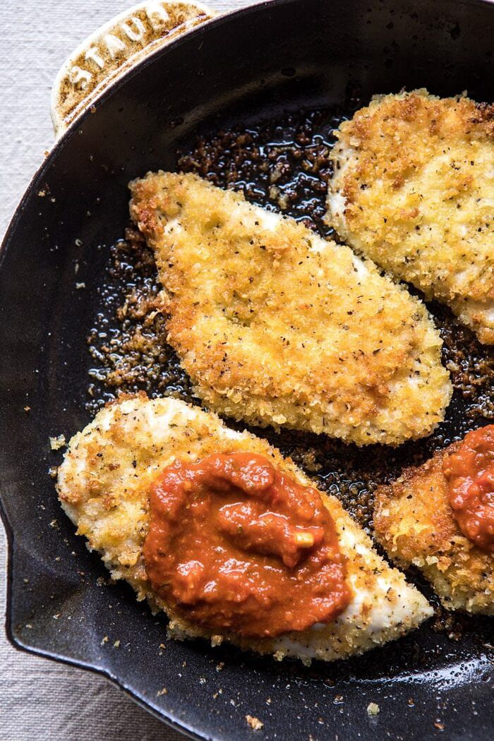Spring Chicken Parmesan with Tuscan Kale Pesto | halfbakedharvest.com #chicken #recipe #healthy photo of Spring Chicken Parmesan in skillet with tomato sauce