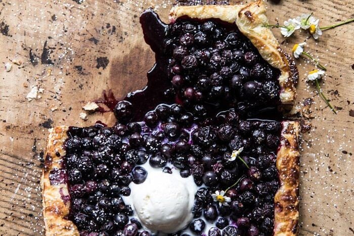 Blueberry Chamomile Galette | halfbakedharvest.com #blueberries #summer #easyrecipes horizontal overhead photo of Blueberry Chamomile Galette with slice missing