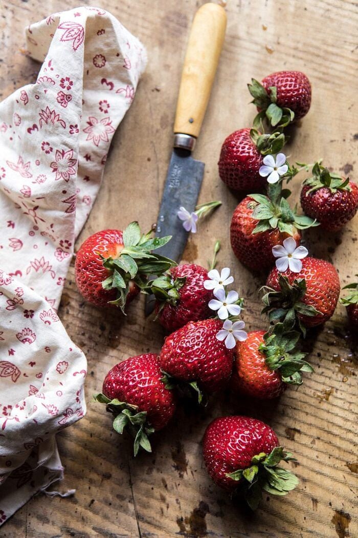 Honey Strawberry Muffins | halfbakedharvest.com #breakfast #summerrecipes #strawberries #muffins overhead photo of strawberries with flowers and pairing knife