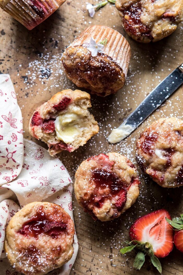 Honey Strawberry Muffins | halfbakedharvest.com #breakfast #summerrecipes #strawberries #muffins overhead photo of half eaten Honey Strawberry Muffins with melting butter