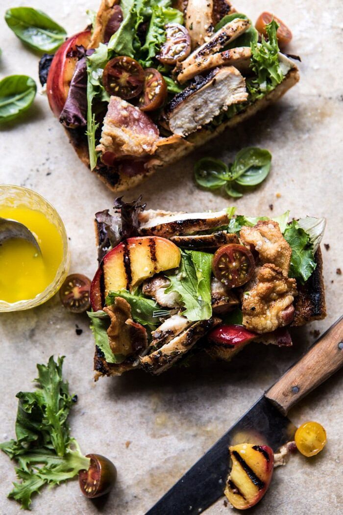 overhead photo of Open Faced Rosemary Chicken, Peach, and Bacon Sandwich with knife and piece missing 