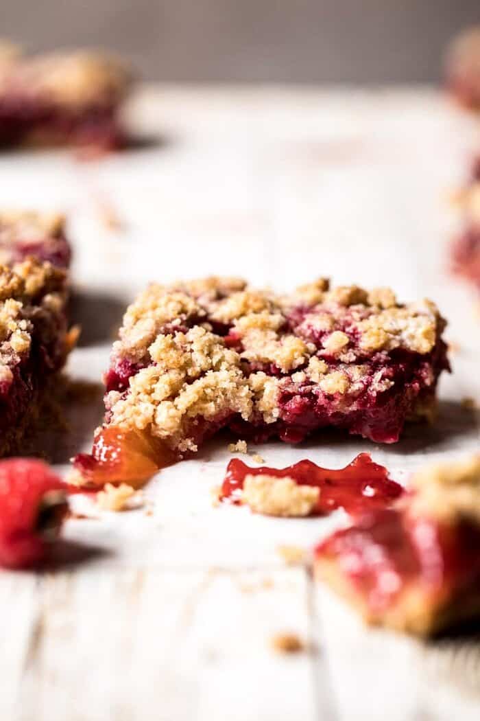 Buttery Raspberry Crumble Bars | halfbakedharvest.com #raspberry #dessert #summer #backtoschool #easyrecipes Buttery Raspberry Crumble Bars broken in half to show the filling