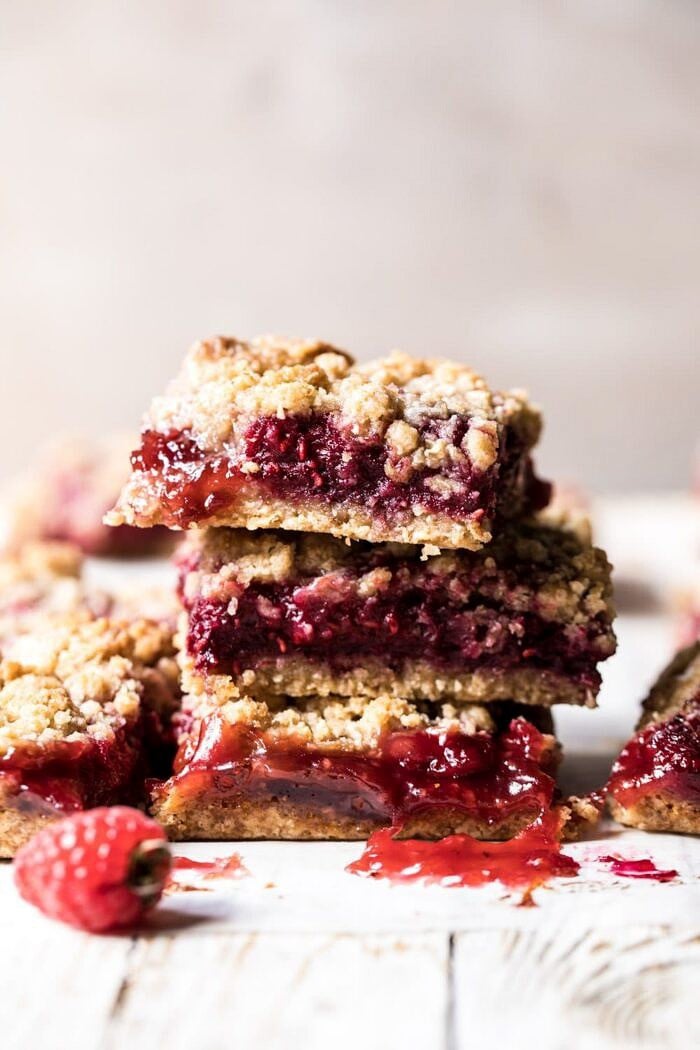 Buttery Raspberry Crumble Bars | halfbakedharvest.com #raspberry #dessert #summer #backtoschool #easyrecipes Buttery Raspberry Crumble Bars stacked on top of each other
