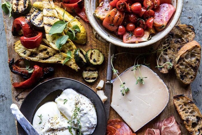 horizontal overhead photo of Marinated Tomato and Grilled Veggie Cheese Board 