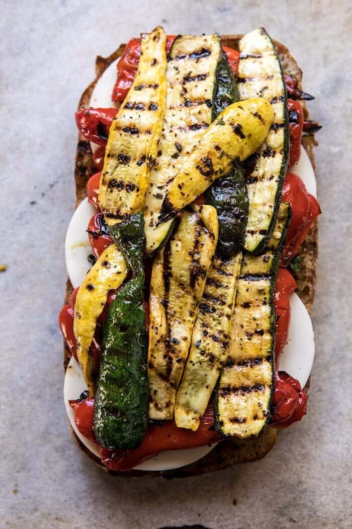 overhead photo of Marinated Veggie Cheese Sandwich with Sun-Dried Tomato Pesto and grilled zucchini on top