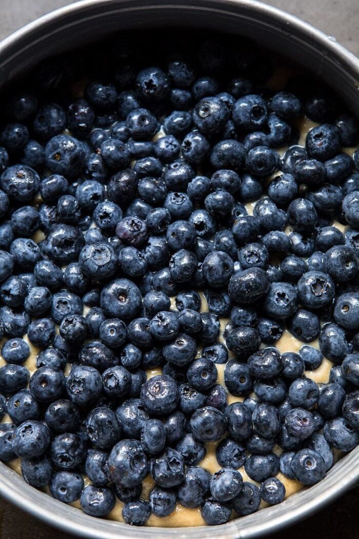 Bursting Blueberry Cardamom Buckle | halfbakedharvest.com #blueberry #cake #summerrecipes #easyrecipes #dessert overhead photo of blueberries on top of buckle batter before baking