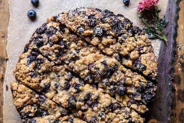 Bursting Blueberry Cardamom Buckle | halfbakedharvest.com #blueberry #cake #summerrecipes #easyrecipes #dessert overhead photo of Bursting Blueberry Cardamom Buckle with knife in photo