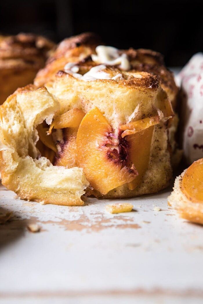 Flaky Pull Apart Cinnamon Peach Brioche Bread | halfbakedharvest.com #bread #brunch #breakfast #peaches #summer #baking front on photo of Flaky Pull Apart Cinnamon Peach Brioche Bread torn open to expose the peaches