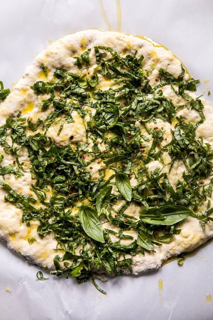 overhead photo of pizza dough with pesto