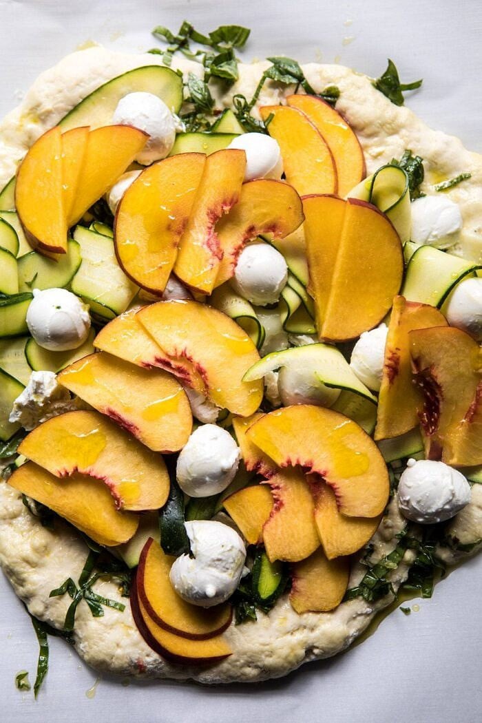 Pesto Zucchini and Peach Pizza with Burrata before going into the oven