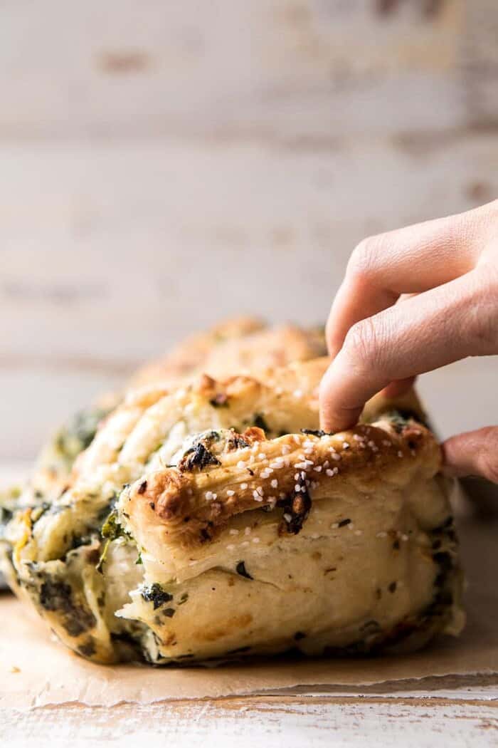 front angle photo of Herbed Spinach and Artichoke Pull Apart Pretzel Bread being pulled apart 