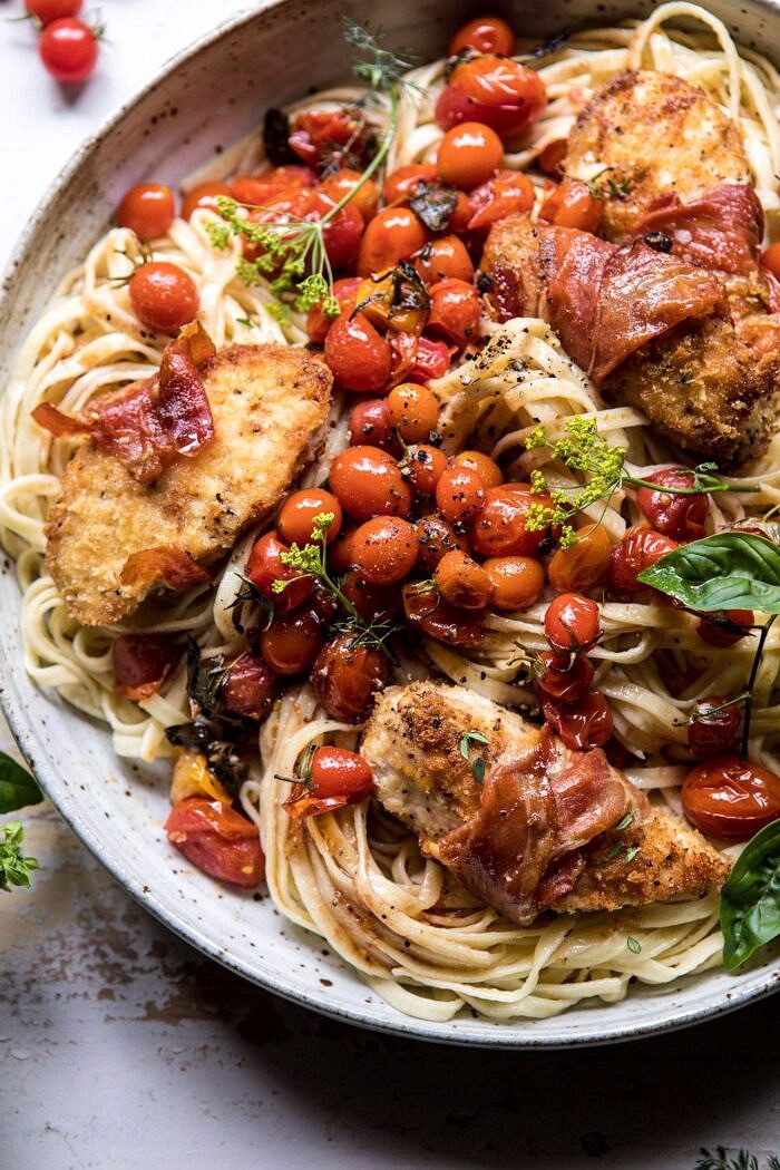 Prosciutto Chicken Parmesan with Garlic Butter Tomato Pasta | halfbakedharvest.com #pasta #easyrecipe #tomatoes #familyrecipes close up photo of Prosciutto Chicken Parmesan with Garlic Butter Tomato Pasta
