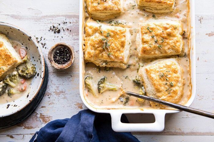 horizontal photo of Homemade Broccoli Cheddar Cobbler with spoon is baking dish
