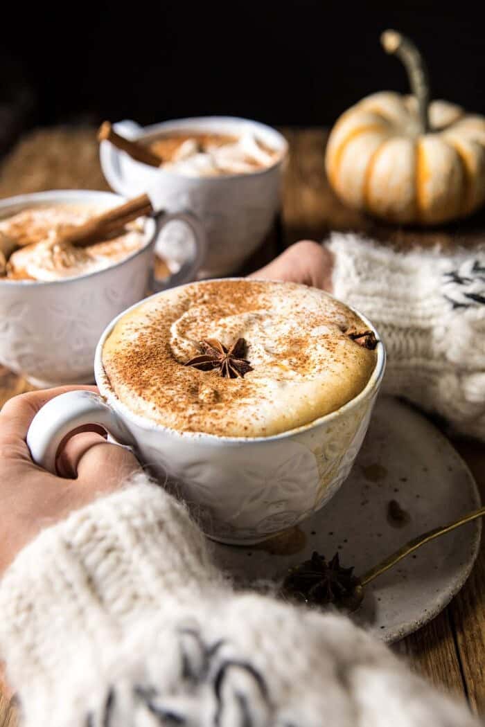 Spiced Pumpkin Maple Latte | halfbakedharvest.com #pumpkinspice #pumpkin #latte #fall #autumn #healthy Spiced Pumpkin Maple Latte with hands on mug and 3 mugs in photo