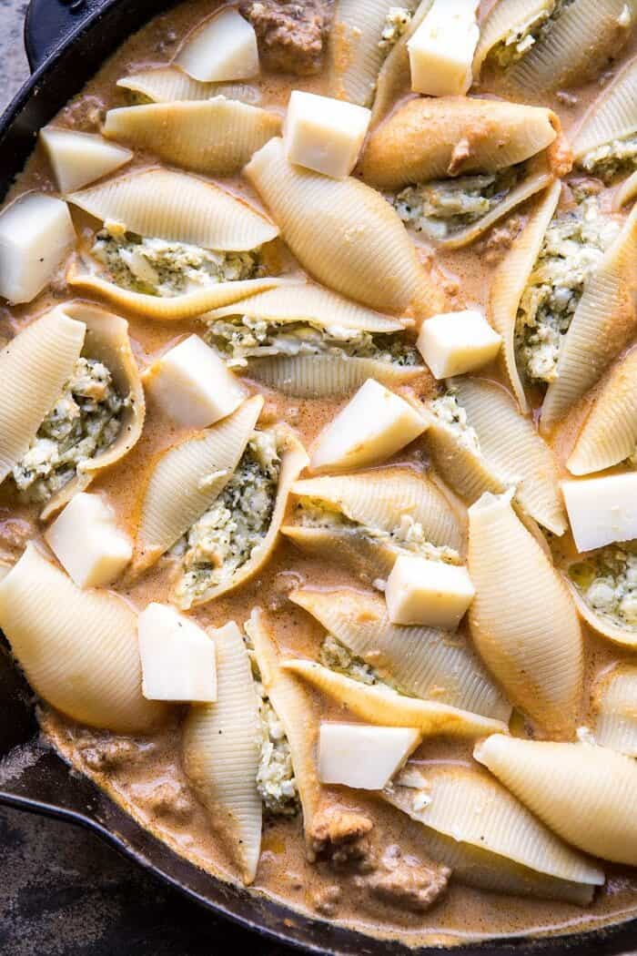 Spicy Pumpkin and Pesto Cheese Stuffed Shell | halfbakedharvest.com #pumpkin #pasta #Italian #easy #dinner #fall #fallrecipes Spicy Pumpkin and Pesto Cheese Stuffed Shells in skillet before baking