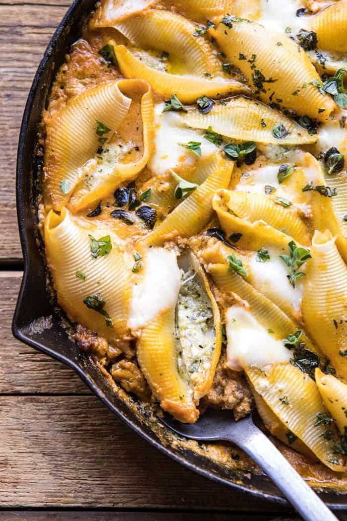 Spicy Pumpkin and Pesto Cheese Stuffed Shells | halfbakedharvest.com #pumpkin #pasta #Italian #easy #dinner #fall #fallrecipes close up photo Spicy Pumpkin and Pesto Cheese Stuffed Shells with spoon in skillet