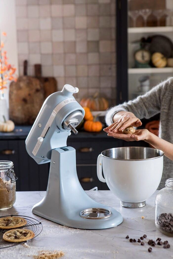 KitchenAid on counter and cookie dough being rolled into cookies