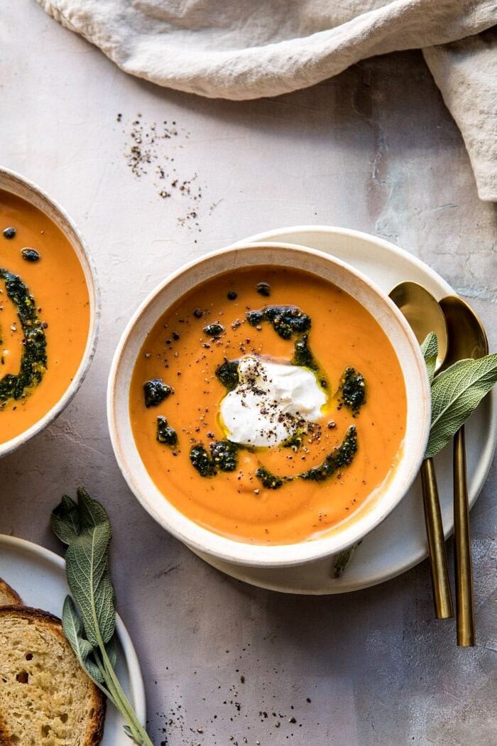 overhead photo of Golden Sweet Potato Soup with Burrata and Sage Pesto with towel and bread in photo 
