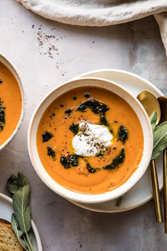 overhead close up photo of Sweet Potato Soup with Burrata and Sage Pesto with towel and bread in photo 