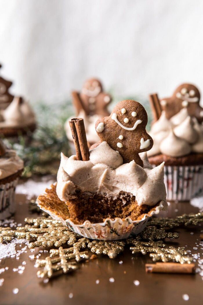 Gingerbread Cupcakes with Cinnamon Browned Butter Buttercream | halfbakedharvest.com #gingerbread #cupcakes #dessert #holiday #easyrecipes #christmas side angle photo of Gingerbread Cupcakes with Cinnamon Browned Butter Buttercream with bite take out of cupcake