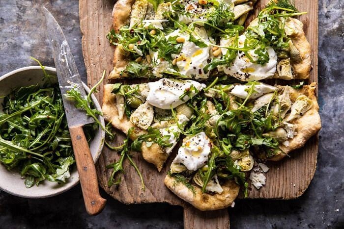 horizontal photo of Artichoke Pesto and Burrata Pizza with Lemony Arugula 