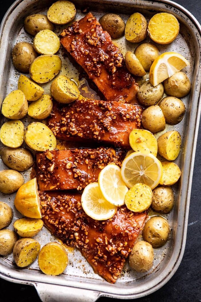 salmon and potatoes on baking sheet before baking