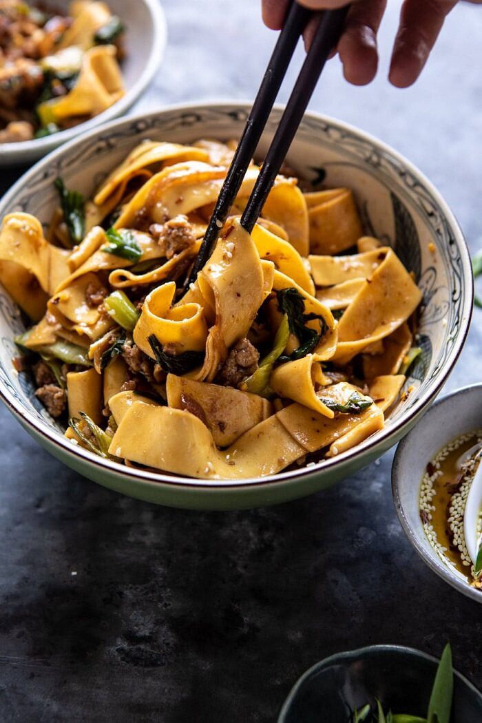 side angled photo of Better Than Takeout Szechuan Noodles with Sesame Chili Oil with chopsticks in bowl 