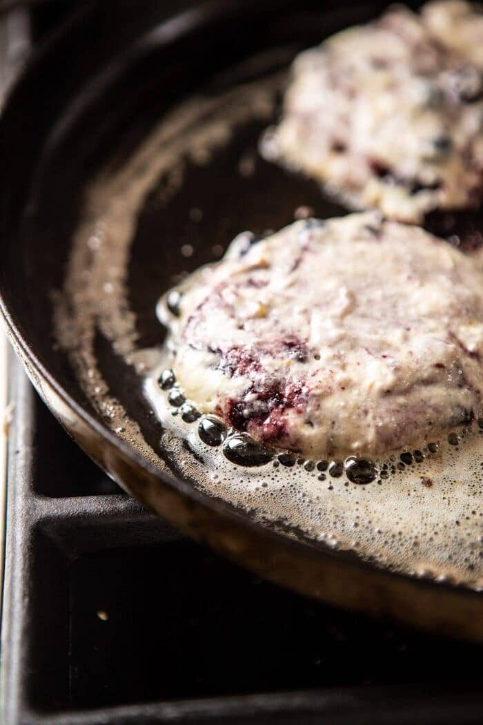 Blueberry Lemon Ricotta Pancakes on skillet cooking