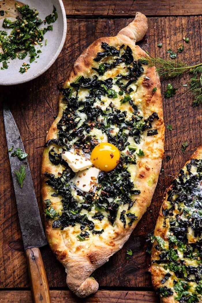 overhead photo of Khachapuri (Georgian Cheese Bread) with Kale and Herb Sauce 