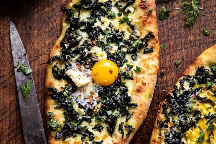 horizontal photo of Khachapuri (Georgian Cheese Bread) with Kale and Herb Sauce
