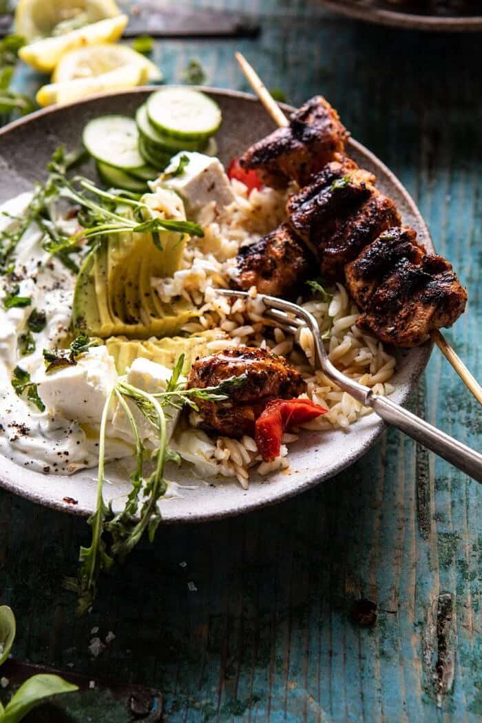 side angled photo of Greek Lemon Chicken Bowls with Sizzled Mint Goddess Sauce and fork in bowl 