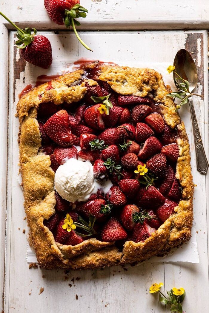 Jammy Strawberry Galette | halfbakedharvest.com #strawberries #tart #summer #fruit #springrecipes overhead photo of Jammy Strawberry Galette with ice cream on top of galette