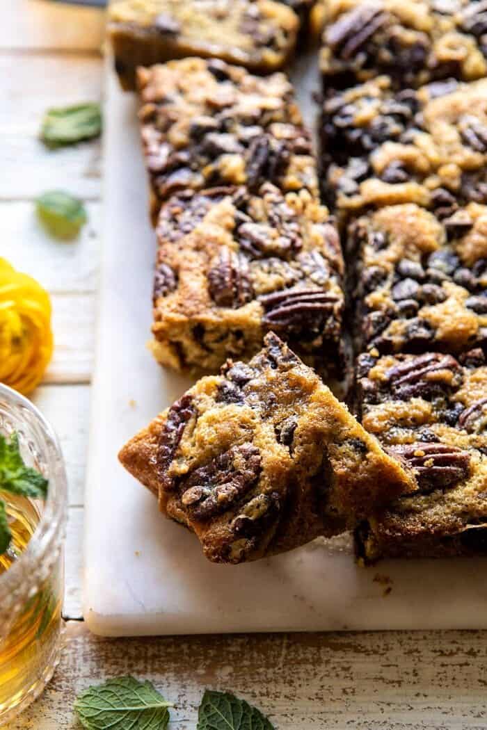 Kentucky Derby Pie Chocolate Chip Cookie Bars | halfbakedharvest.com #cookiebars #pecanpie #chocolatechip #dessert side angled photo of Kentucky Derby Pie Chocolate Chip Cookie Bars