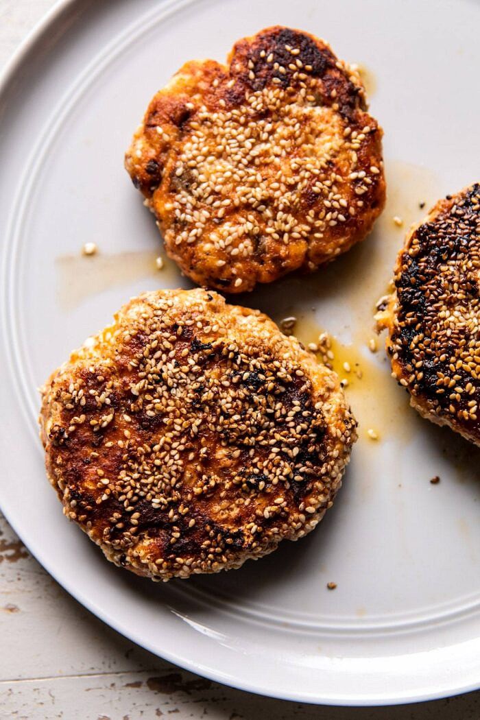 Sesame Crusted Curried Salmon Burgers with Lemony Herbs | halfbakedharvest.com #salmon #healthy #burger #summer overhead close up photo of Sesame Crusted Curried Salmon Burgers on plate