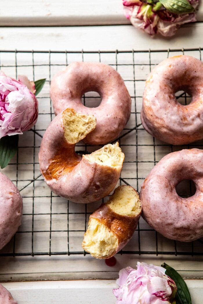 Strawberry Glazed Chai Doughnuts | halfbakedharvest.com #doughnuts #spring #strawberries Strawberry Glazed Chai Doughnuts with bite taken out of doughnut
