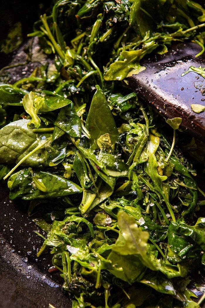 Turkish Eggs with Chile Butter and Whipped Feta | halfbakedharvest.com #breakfast #brunch #healthyrecipes #eggs #spring #summer garlicy greens in skillet