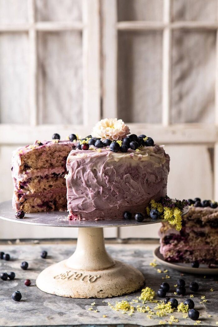 Bursting Blueberry Lemon Layer Cake | halfbakedharvest.com #bleberrycake #layercake #summerrecipes #dessert front on photo of Bursting Blueberry Lemon Layer Cake with slices cut out