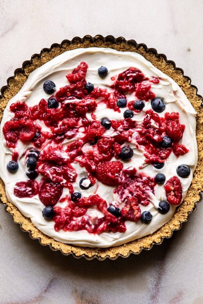 No-Bake Eton Mess Berry Cheesecake | halfbakedharvest.com #cheesecake #nonbake #easyrecipes #dessert #4thofjuly overhead photo of No-Bake Eton Mess Berry Cheesecake before chilling and adding toppings