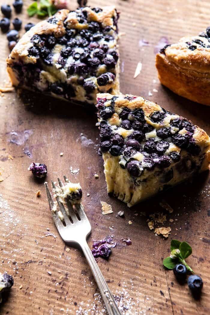 Simple Blueberry Basque Cheesecake | halfbakedharvest.com #cheesecake #blueberries #cake #easyrecipes side angled photo of Simple Blueberry Basque Cheesecake slice with bite take out of slice