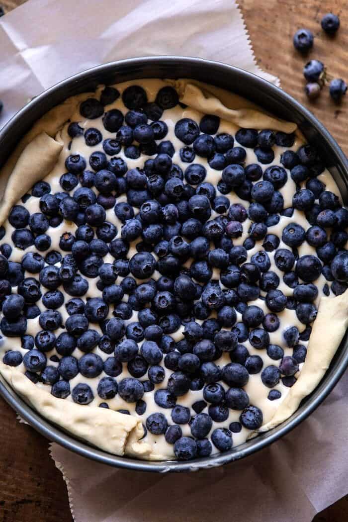 Simple Blueberry Basque Cheesecake | halfbakedharvest.com #cheesecake #blueberries #cake #easyrecipes overhead photo of Simple Blueberry Basque Cheesecake in spring form pan before baking