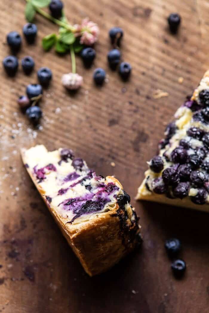 Simple Blueberry Basque Cheesecake | halfbakedharvest.com #cheesecake #blueberries #cake #easyrecipes close up photo of Simple Blueberry Basque Cheesecake slice to show the puff pastry crust