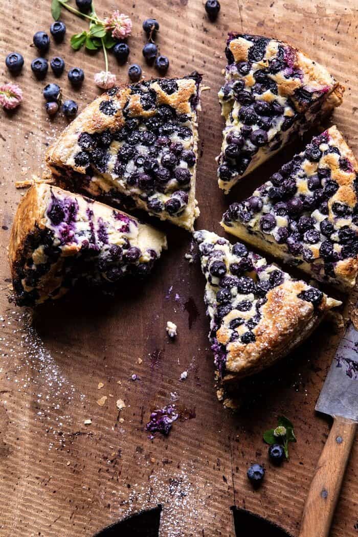 Simple Blueberry Basque Cheesecake | halfbakedharvest.com #cheesecake #blueberries #cake #easyrecipes overhead photo of Simple Blueberry Basque Cheesecake with 2 slices missing from cake
