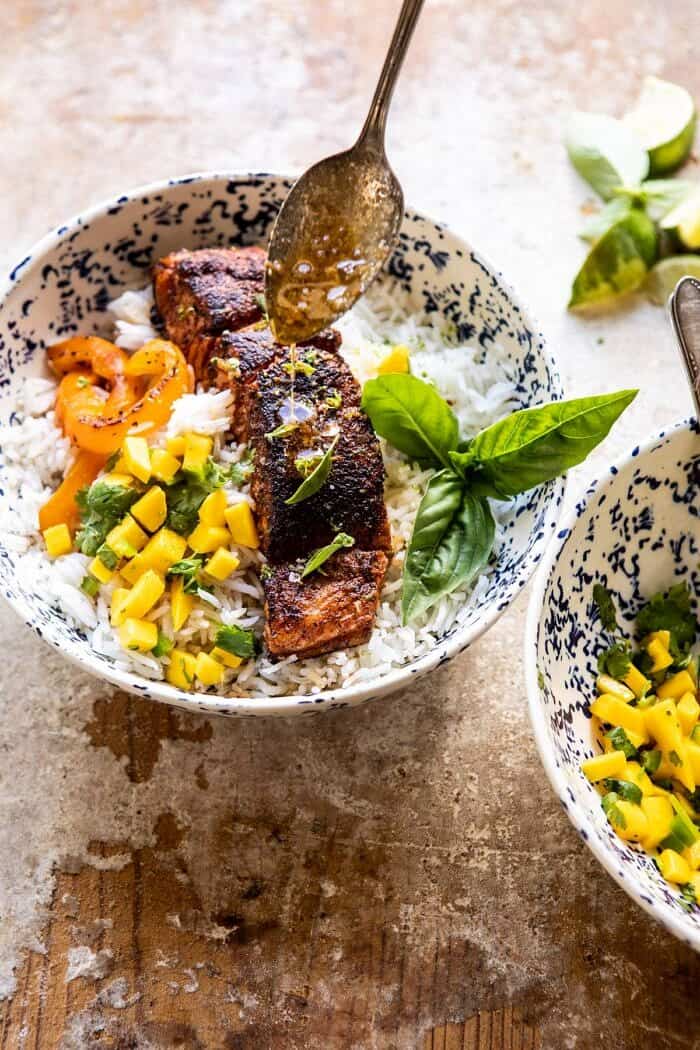 Cilantro Lime Salmon with Mango Salsa | halfbakedharvest.com #salmon #easyrecipes #healthyrecipes #dinner overhead photo of Cilantro Lime Salmon with Mango Salsa with chili lime butter being drizzled over top salmon