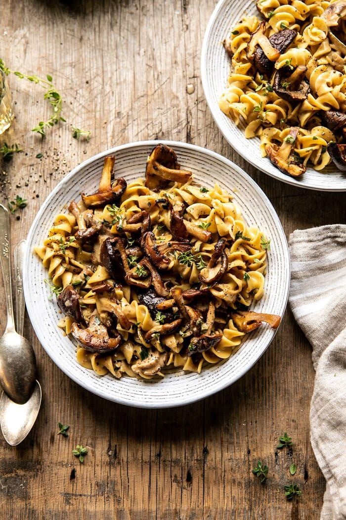 Herby Buttered Mushroom Stroganoff | halfbakedharvest.com #easyrecipes #familydinner #autumn #cozyrecipes #fallrecipes overhead photo of Herby Buttered Mushroom Stroganoff with 2 bowls and 2 spoons in photo