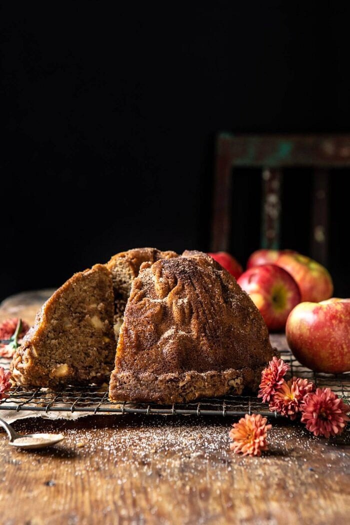 side angled close up photo of Spiced Pecan Apple Cider Doughnut Cake with slice cut out
