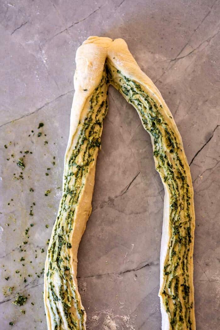 Swirled Garlic Herb Bread | halfbakedharvest.com #garlicbread #herbbread #homemadebread dough log sliced in half and twisted to show the inside before braiding